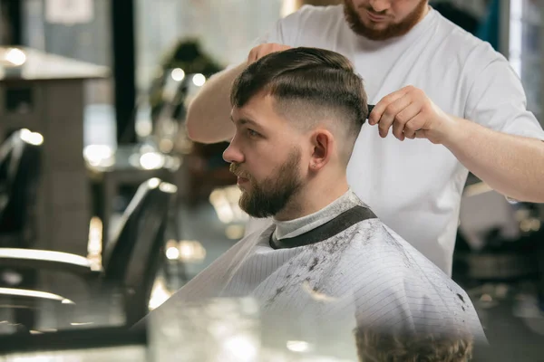 マスター理容師を閉じ、スタイリストは男、若い男にヘアスタイルを行います。職業、男性の美しさの概念 — ストック写真