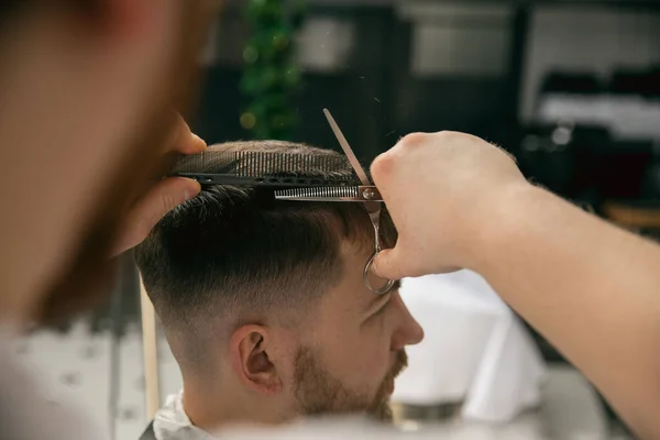 Friseurmeister aus nächster Nähe, Stylist frisiert den jungen Mann. Professionelle Beschäftigung, männliches Schönheitskonzept — Stockfoto