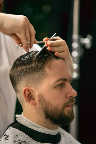 Närbild av klient master barberare, stylist under att få vård av frisyr. Yrke, manligt skönhetskoncept — Stockfoto