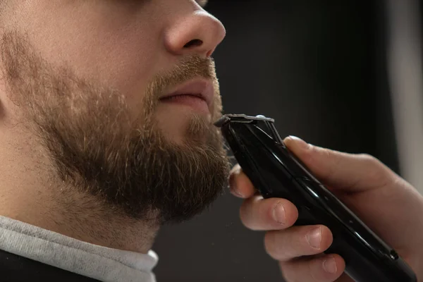 Крупним планом клієнт майстра перукарні, стиліст під час догляду за вусами і бородою. Професійна професія, концепція краси чоловіків — стокове фото