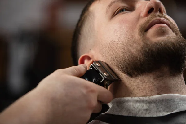 Großaufnahme vom Kunden des Friseurmeisters, Stylisten während der Pflege von Schnurrbart und Bart. Professionelle Beschäftigung, männliches Schönheitskonzept — Stockfoto