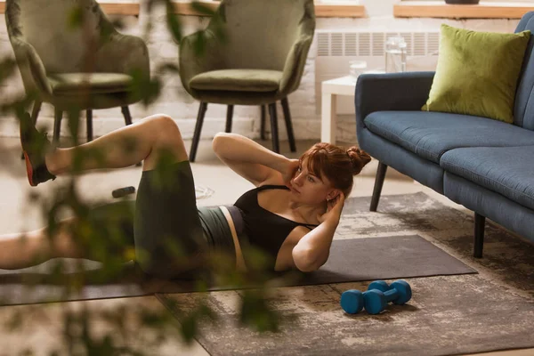 Mujer joven ejercitando fitness, aeróbico, yoga en casa, estilo de vida deportivo. Activarse durante el encierro, cuarentena. Gimnasio. — Foto de Stock