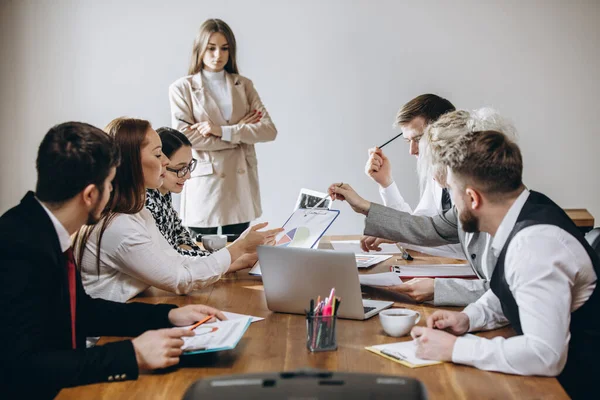 Kvinnlig talare ger presentation i salen på workshop. Publiken eller konferenslokalen. Deltagare, medarbetare som lyssnar vid bordet. — Stockfoto