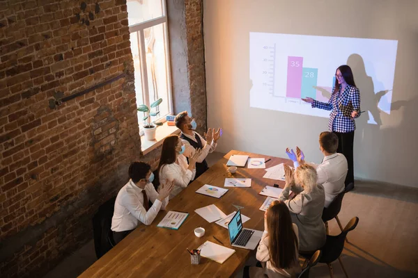Female speaker giving presentation in hall at workshop. Audience or conference hall. Participants, co-workers listening at the table. — Stock Photo, Image