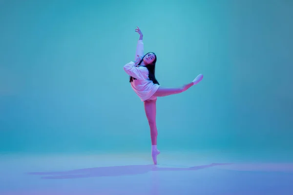 Young and graceful ballet dancer isolated on blue studio background in neon light. Art, motion, action, flexibility, inspiration concept. — Stock Photo, Image