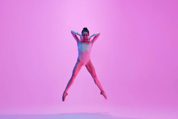 Young and graceful ballet dancer isolated on pink studio background in neon light. Art, motion, action, flexibility, inspiration concept. — Stock Photo, Image