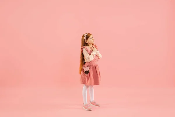 Childhood and dream about big and famous future. Pretty longhair girl isolated on coral pink background — Stock Photo, Image