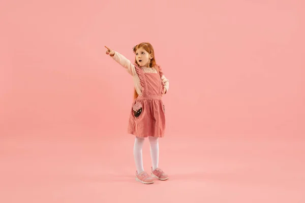 Childhood and dream about big and famous future. Pretty longhair girl isolated on coral pink background — Stock Photo, Image