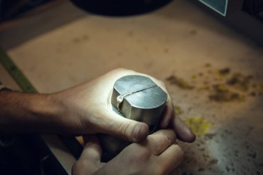 Mücevhercilerin, kuyumcuların, altın yüzüklerden profesyonel aletler kullanan kuyumcuların ellerini kapatın..