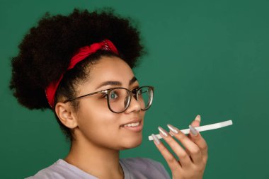 Afro-Amerikalı kadın portresi, yeşil stüdyo arka planında kopyalanmış.