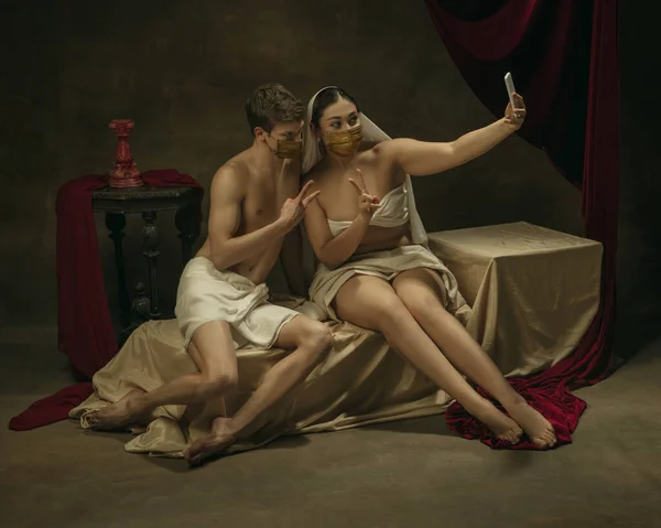 Remake moderno de arte clássica com tema de tecnologia moderna - jovem casal medieval em fundo escuro — Fotografia de Stock