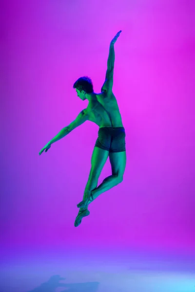 Young and graceful ballet dancer isolated on purple studio background in neon light. Art, motion, action, flexibility, inspiration concept. — Stock Photo, Image