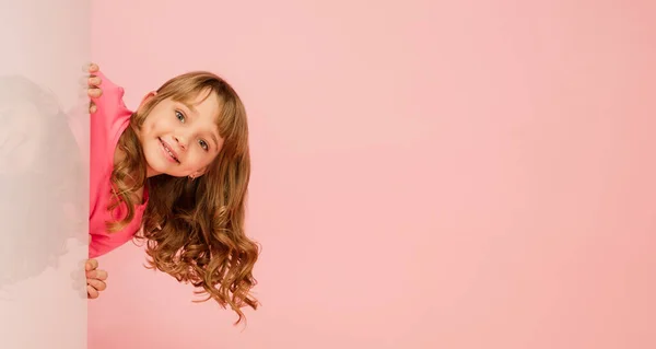 幸せな子供は、女の子のサンゴピンクのスタジオの背景に隔離された。幸せで陽気で誠実なようだ。コピースペース。子供時代教育感情概念 — ストック写真
