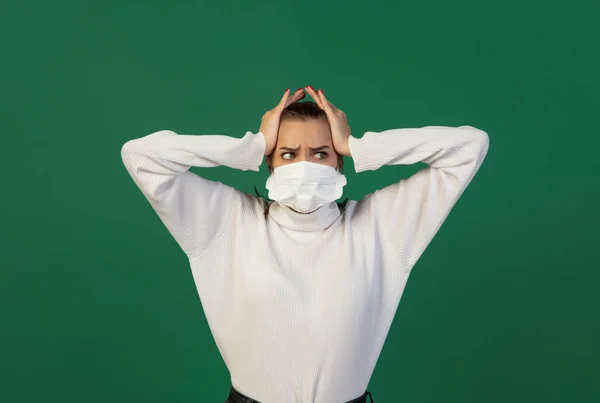 Mulher em máscara protetora isolada no fundo do estúdio verde. Novas regras de prevenção da propagação COVID — Fotografia de Stock