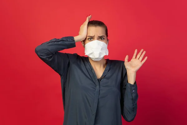 Mulher em máscara protetora isolada no fundo do estúdio vermelho. Novas regras de prevenção da propagação COVID — Fotografia de Stock