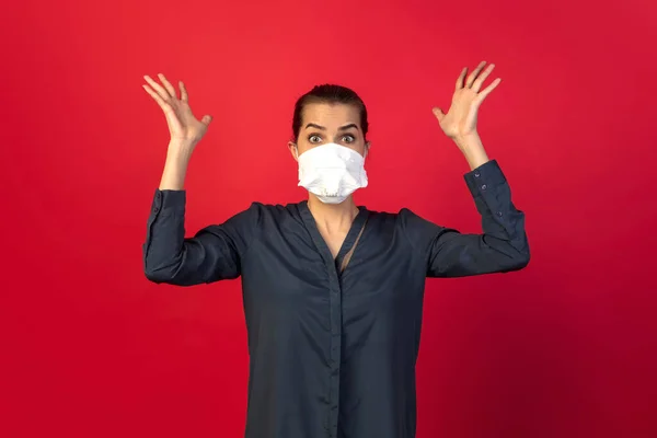 Mulher em máscara protetora isolada no fundo do estúdio vermelho. Novas regras de prevenção da propagação COVID — Fotografia de Stock