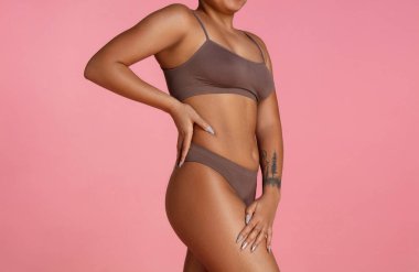 Pembe stüdyo arka planında izole edilmiş güzel bir Afrikalı-Amerikalı kadın vücudu.