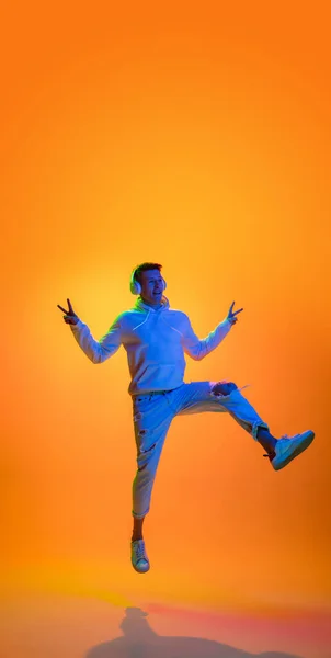 Caucásico hermoso retrato mans aislado sobre fondo de estudio amarillo en luz de neón multicolor —  Fotos de Stock