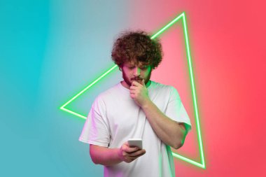 Beyaz adam portresi, parlak üçgenli neon ışıklı mavi-kırmızı stüdyo arka planında izole edilmiş. İnsan duyguları kavramı, yüz ifadesi, satış, reklam.