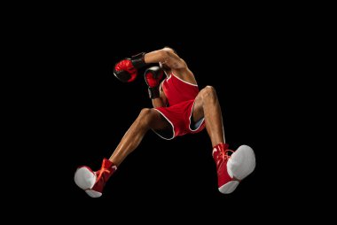 Genç Afro-Amerikan boksör, hareket halinde, siyah arka planda izole edilmiş, aşağıdan bak. Spor, hareket, enerji ve dinamik kavramı.