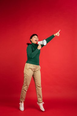 Doğu Asyalı kadın portresi kırmızı stüdyo arka planında kopyalanmış.