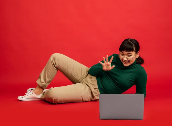 East asian womans portrait isolated on red studio background with copyspace