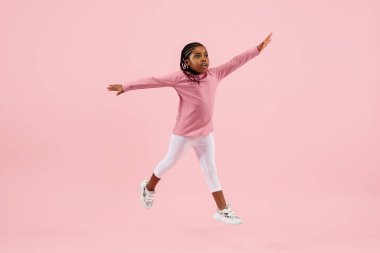 Çocukluk ve büyük ve ünlü bir gelecek hayal etmek. Mercan pembe arka planda izole edilmiş güzel küçük kız.