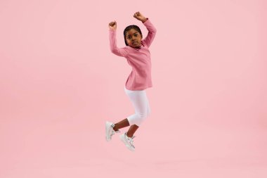 Çocukluk ve büyük ve ünlü bir gelecek hayal etmek. Mercan pembe arka planda izole edilmiş güzel küçük kız.