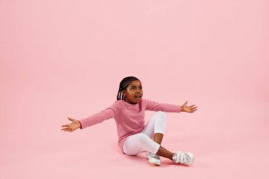 Çocukluk ve büyük ve ünlü bir gelecek hayal etmek. Mercan pembe arka planda izole edilmiş güzel küçük kız.