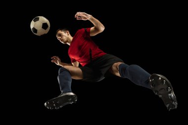 Kafkasyalı genç futbolcu, futbol oyuncusu, siyah arka planda izole hareket, aşağıdan bak. Spor, hareket, enerji ve dinamik kavramı.