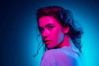 Kafkas kadın portresi mavi stüdyo arka planında çok renkli neon ışıklarla izole edilmiş.