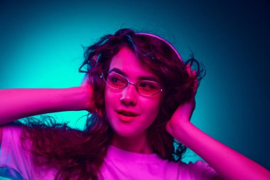 Kafkas kadın portresi mavi stüdyo arka planında çok renkli neon ışıklarla izole edilmiş.