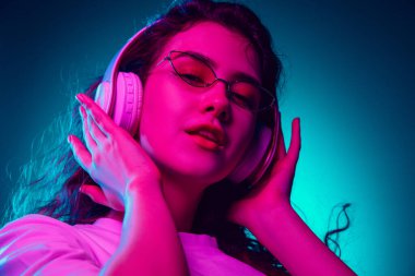 Kafkas kadın portresi mavi stüdyo arka planında çok renkli neon ışıklarla izole edilmiş.