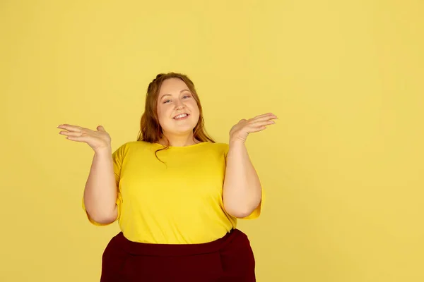 Bonito modelo caucasiano plus size isolado no fundo do estúdio amarelo. Conceito de inclusão, emoções humanas, expressão facial — Fotografia de Stock