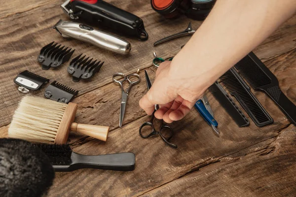 Mano di barbiere maschile con set di attrezzature isolato su sfondo tavolo di legno. — Foto Stock