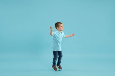 Çocukluk ve büyük ve ünlü bir gelecek hayal etmek. Güzel küçük çocuk mavi arka planda izole edilmiş