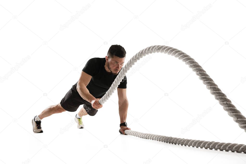 Caucasian professional sportsman training isolated on white studio background. Muscular, sportive man practicing.