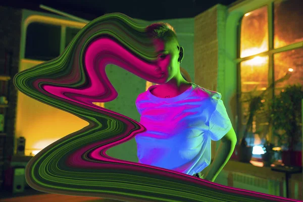 Portrét stylové ženy v neonově osvětleném interiéru. Tvář je rozmazaná, nasáklá do obrazovky. Koncept závislosti na sociálních sítích — Stock fotografie