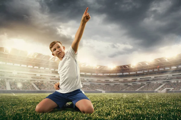 Junior football or soccer player at stadium - motion, action, activity concept