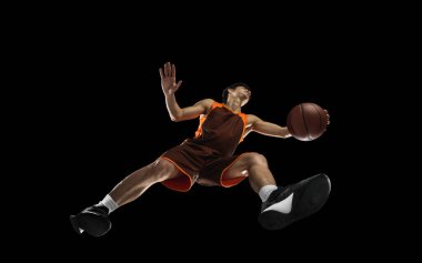 Genç profesyonel basketbolcu, siyah arka planda izole hareket, aşağıdan bak. Spor, hareket, enerji ve dinamik kavramı.