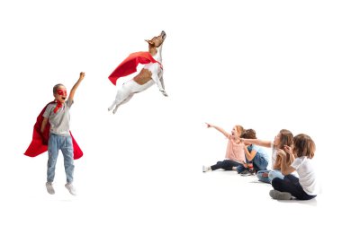 Süper köpeği ve arkadaşları etrafta otururken süper kahraman gibi davranan çocuk.