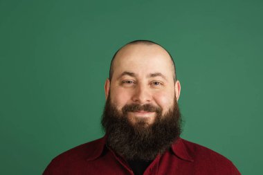 Yeşil stüdyo arka planında kopyalanmış yakışıklı beyaz adam portresi