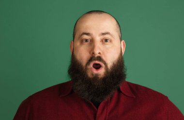 Yeşil stüdyo arka planında kopyalanmış yakışıklı beyaz adam portresi