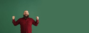 Yeşil stüdyo arka planında kopyalanmış yakışıklı beyaz adam portresi