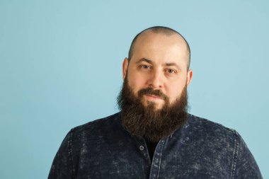 Mavi stüdyo arka planında kopyalanmış yakışıklı beyaz erkek portresi