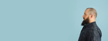 Mavi stüdyo arka planında kopyalanmış yakışıklı beyaz erkek portresi