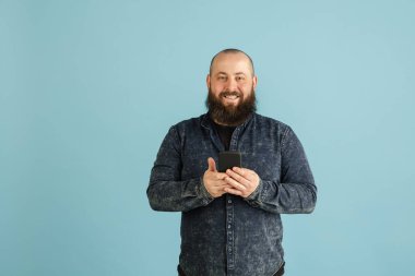 Mavi stüdyo arka planında kopyalanmış yakışıklı beyaz erkek portresi