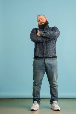 Mavi stüdyo arka planında kopyalanmış yakışıklı beyaz erkek portresi