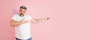 Yakışıklı beyaz erkek model mercan pembe stüdyo arka planında izole edilmiş. Kapsama kavramı, insan duyguları, yüz ifadesi