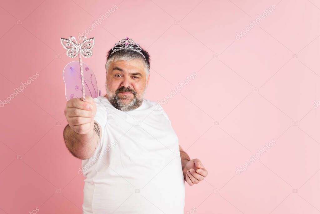 Handsome caucasian plus size male model isolated on coral pink studio background. Concept of inclusion, human emotions, facial expression